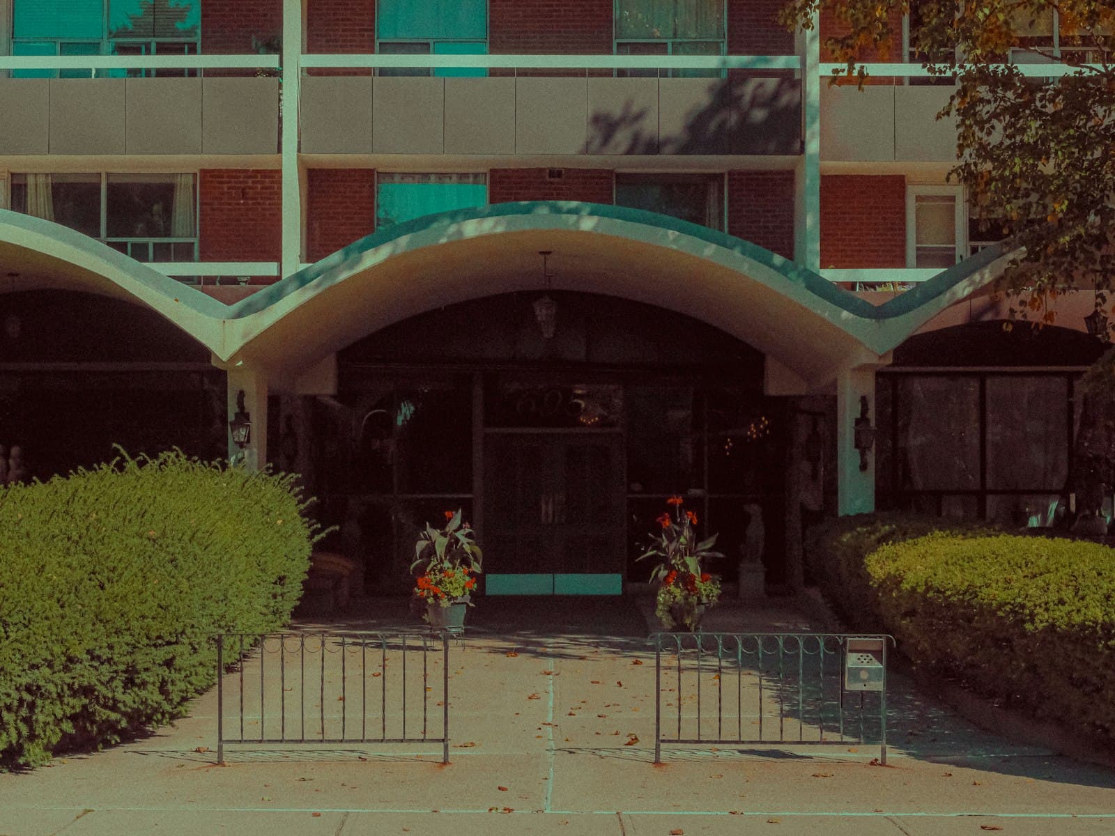 Entrance of a mid-century modern apartment building with street address markings