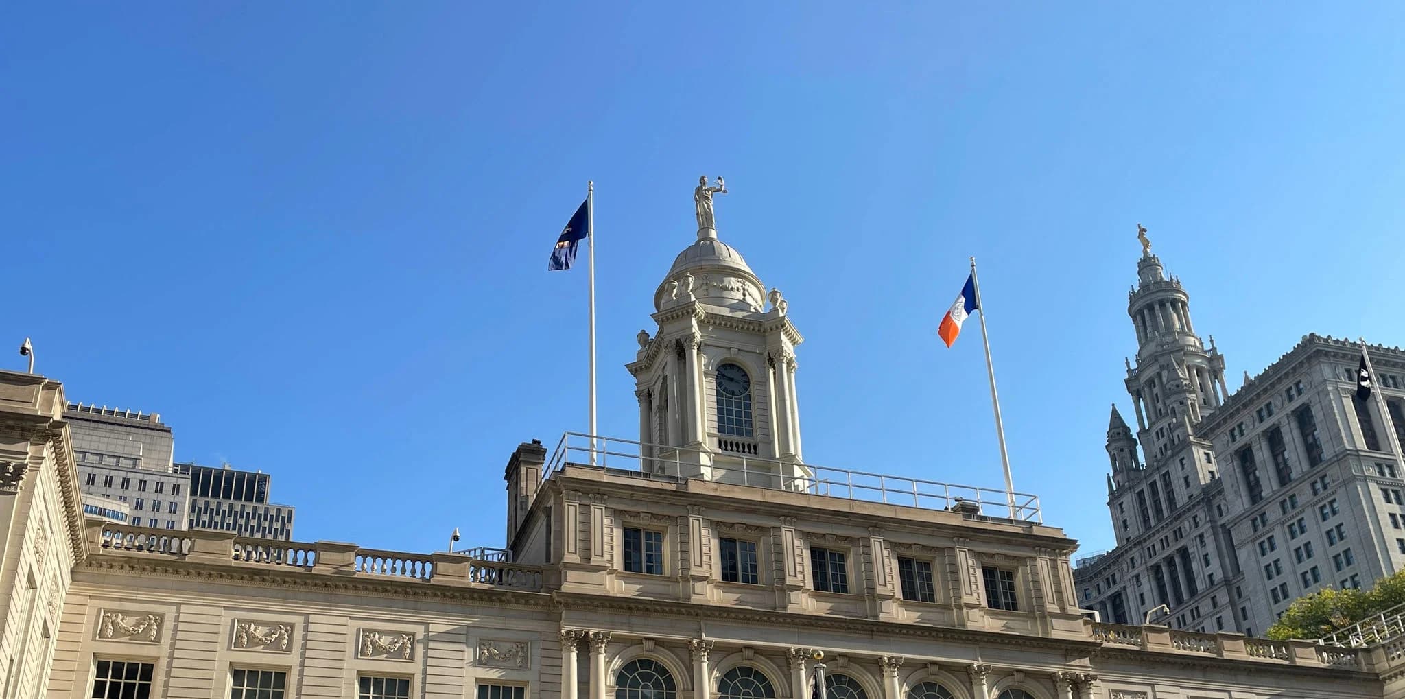 NYC City Hall building against a clear blue sky