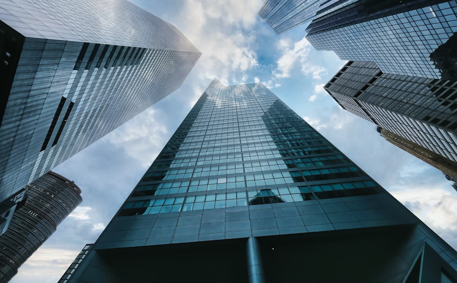 Low-angle view of a glass high-rise office building against the sky